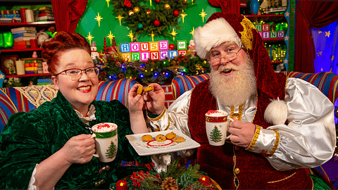 Santa and Mrs. Claus enjoy a cup of cocoa by the fireplace.