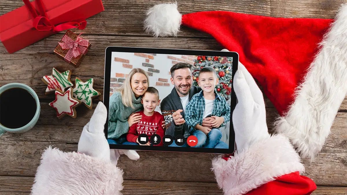 A pair of Santa hands hold a tablet and we see a family having a FaceTime with Santa