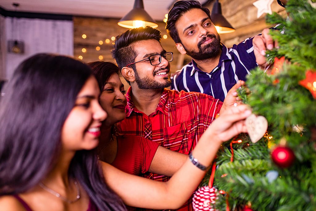 Freinds Decorating A Christmas Tree