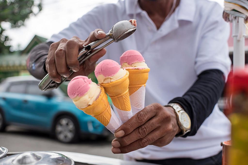 A Sorbetero Scoops Strawberry And Cheese Sorbetes Into In Small