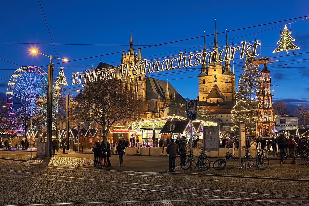 Erfurt, Germany. Christmas market at Domplatz on the background of St Mary's Cathedral and Church of St Severus in twilight.