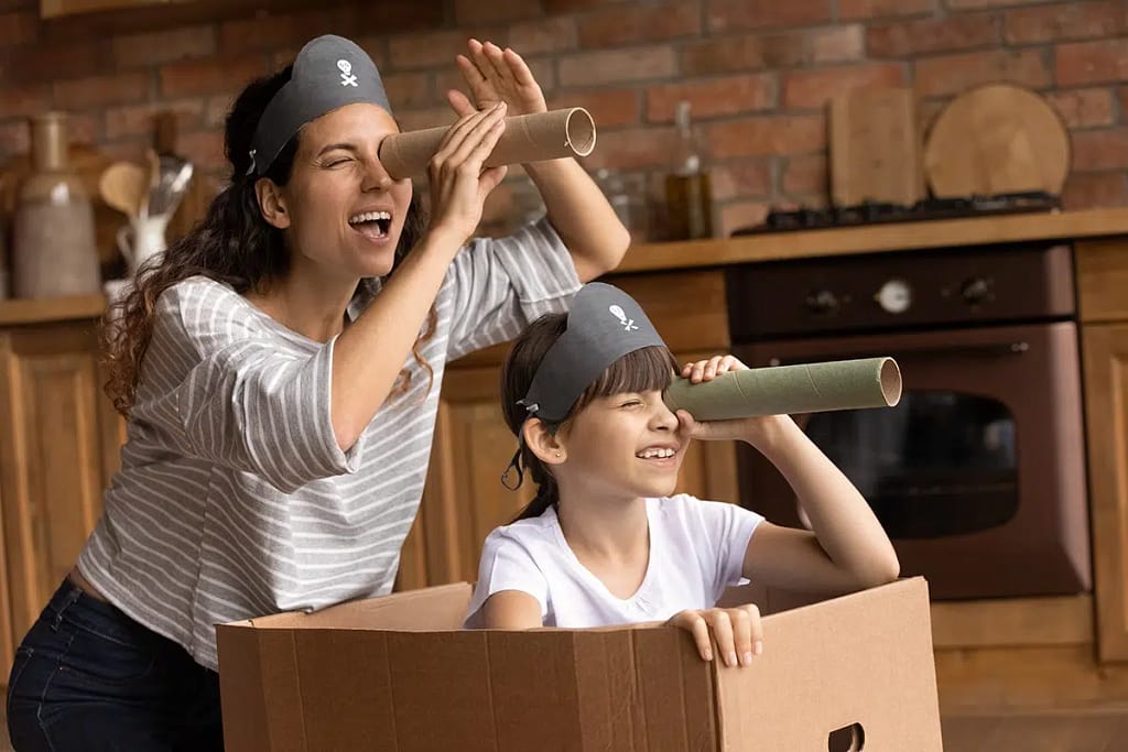 Overjoyed Young Hispanic Mother And Little 7s Daughter Have Fun Playing Pirates Game At Home Together