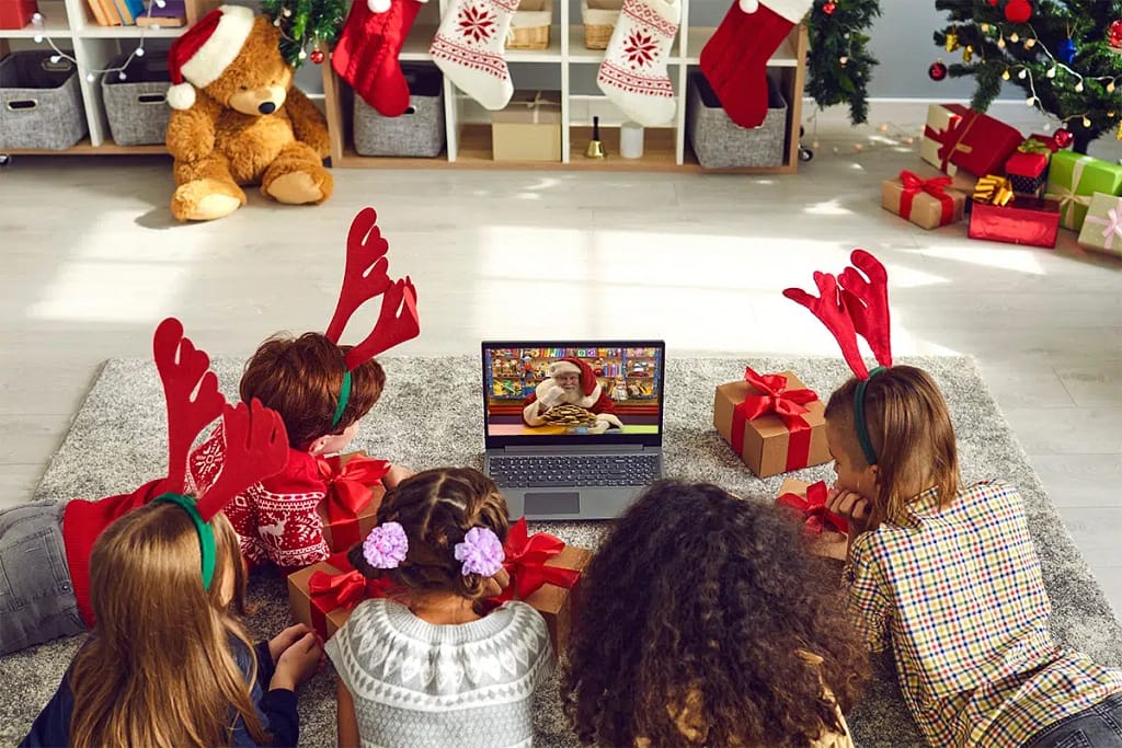 A group of children with red reindeer antlers lie on the floor as they enjoy their Video Call With Santa Claus