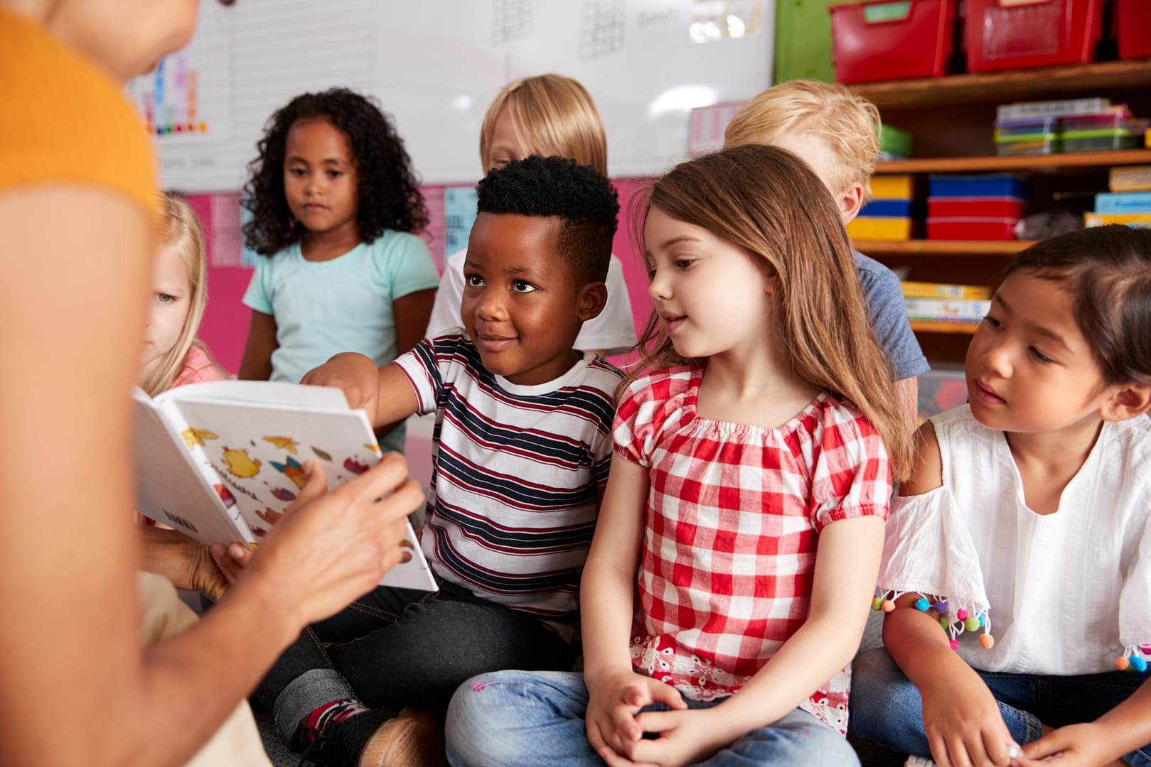 A person reading a book to a group of children